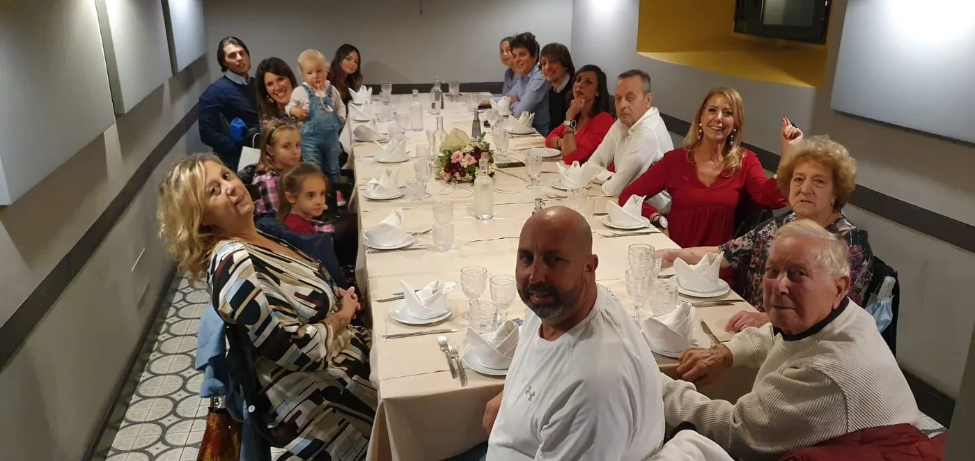 Una tavolata lunga, la famiglia riunita per una cena insieme.